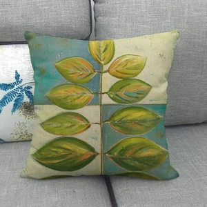 Detailed texture of linen cushion cover featuring watercolor tropical leaf print on sofa