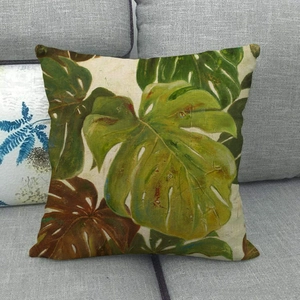 Detail view of tropical monstera leaf linen pillow cover texture on grey sofa