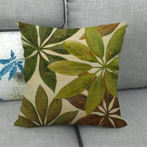 Macro shot of tropical green leaf patterns on a linen textured square cushion cover