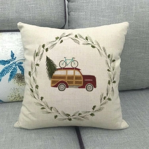 Linen cushion cover with vintage car and Christmas tree design on gray sofa