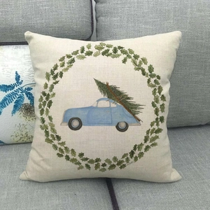 Linen pillowcase with blue car and Christmas tree design on dark gray sofa