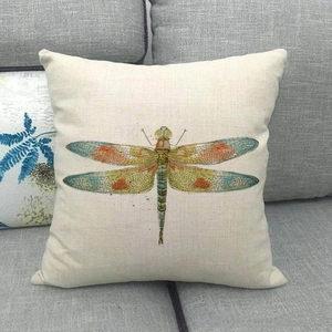 Detailansicht eines Kissenbezugs aus Leinen mit Libellenmotiv auf einem grauen Sofa