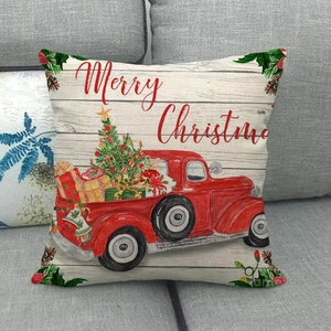 Detalle de funda de cojín de lino con camión de Navidad en un sofá de tela gris