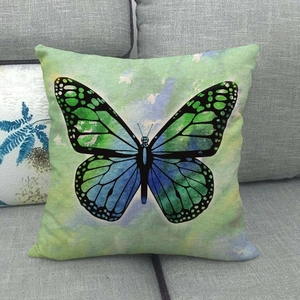 Linen cushion cover featuring watercolor butterfly design on a gray fabric sofa