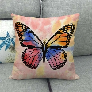 Colorful butterfly linen pillowcase with watercolor tie-dye pattern on a grey sofa