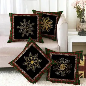 Set of four Christmas plaid throw pillow covers with golden snowflake patterns on a sofa