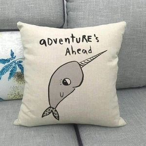 Housse de coussin en lin avec narval de dessin animé sur un canapé gris foncé