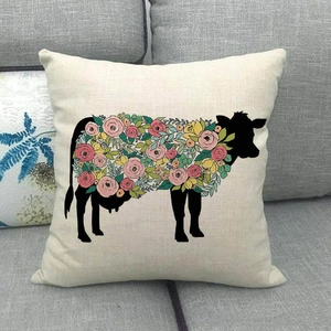 Detail of floral cow silhouette print on beige linen pillow cover on a sofa