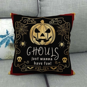 Fodera per cuscino in lino Halloween con zucca dorata e scritta Ghouls sul divano