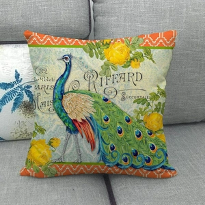 Housse de coussin vintage en lin avec motif paon et fleurs sur un canapé gris