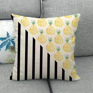 Détail du coussin en lin montrant des motifs d'ananas jaunes et des rayures noires