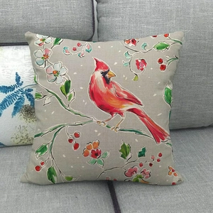 Detailed close-up of a linen pillowcase featuring a red cardinal on floral branches