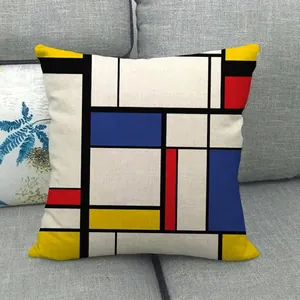 Housse de coussin géométrique en lin avec motif coloré sur un canapé gris