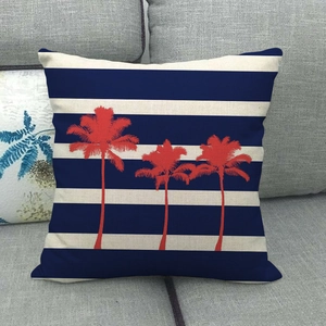 Gros plan de la taie en lin avec rayures bleu marine et motifs de cocotiers orange vif