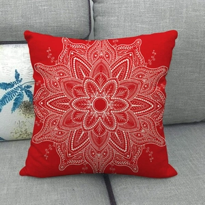Close-up of red linen cushion with white mandala pattern on grey fabric sofa