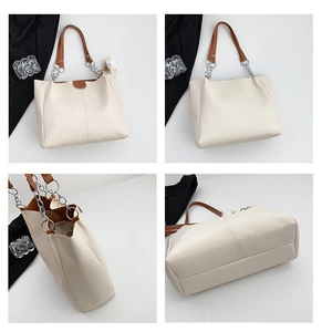 Detail view of cream tote bag with brown leather handles and cute sheep plush charm