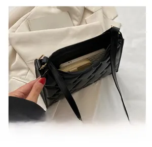 Detail showing the internal storage capacity of the black woven leather shoulder bag