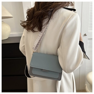 Modern two-tone rectangular crossbody bag with a wide geometric patterned shoulder strap