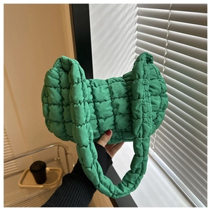 Gros plan sur un sac à bandoulière matelassé vert herbe avec motif à carreaux bouffants