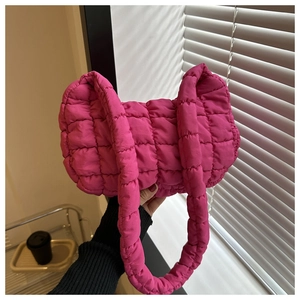 Détail du sac fourre-tout matelassé rouge rose avec texture douce et poignée tissée