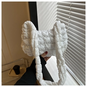 Gros plan du sac nuage matelassé blanc montrant la texture en nylon et la forme plissée