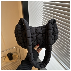 Détail du sac à bandoulière matelassé noir avec texture douce et poignée épaisse