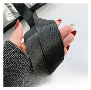 Close-up of a wide black woven shoulder strap for a silver tote bag with soft texture