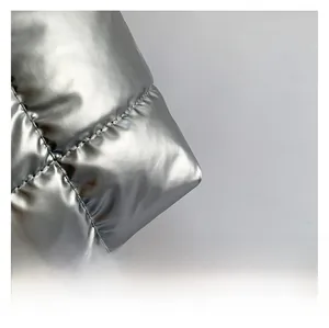 Close-up of silver quilted tote bag fabric with metallic sheen and padded texture