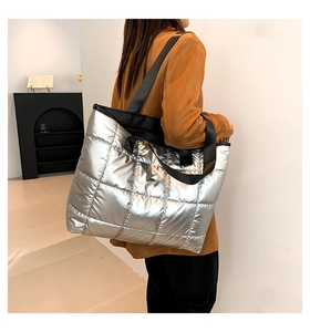 Detail of silver quilted tote bag showing large capacity and black wide shoulder strap