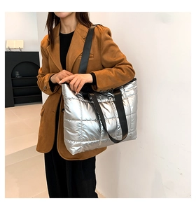 Silver quilted tote bag shown with model in a modern urban minimalist setting