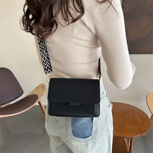 Borsa a tracolla nera minimalista con ampia tracolla a motivi geometrici alla moda