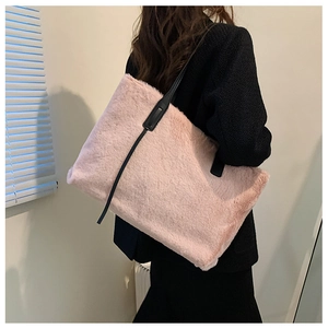 Dettaglio borsa tote in ecopelliccia rosa con spalline nere indossata da una modella