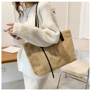 Modella che indossa una grande borsa tote in pelliccia sintetica kaki con tracolla nera
