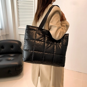 Quilted black nylon puffer tote bag for women showing spacious design and wide strap