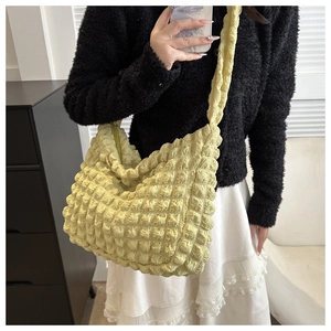 Detail of yellow bubble textured tote bag showing 3D popcorn fabric and soft shoulder strap