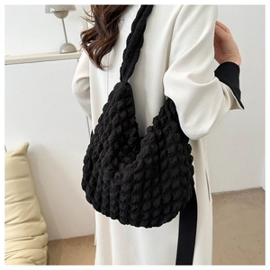 Detail of black popcorn texture fabric on casual shoulder bag shown on model
