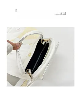 Internal layout of white leather handbag featuring magnetic closure and black lining
