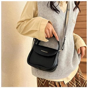 Détail d'un sac bandoulière en cuir noir avec lettrage doré Fashion & Bag élégant