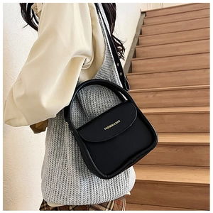 Detail of black leather small square bag with round handle and Fashion & Bag text