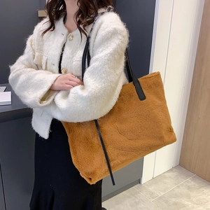 Brown faux fur tote bag with black shoulder straps shown on a model for winter style