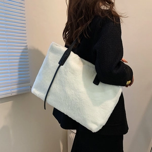 Chic white faux fur tote bag with black leather straps shown on model for autumn winter