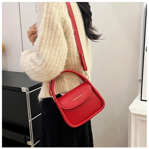 Detail of red leather crossbody bag with gold Fashion & Bag lettering on model