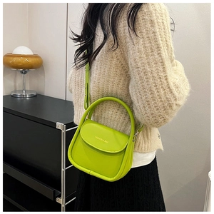 Lime green semi-circular crossbody bag featuring a fashion logo and smooth leather texture