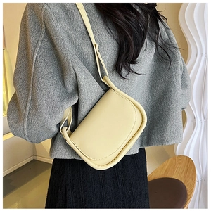 Détail d'un sac besace jaune porté par un mannequin montrant la bandoulière ajustée