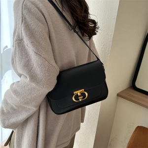 Sac sous l'aisselle en cuir noir minimaliste avec boucle dorée sur un mannequin