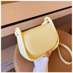 Vue à la main d'un sac besace minimaliste jaune clair avec bandoulière réglable