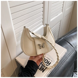 Detail of off-white hobo bag with silver butterfly buckle and woven handle grip