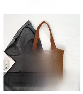 Dettaglio della borsa tote in peluche marrone con etichetta FASHION e manici