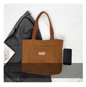 Dettaglio della borsa tote in peluche marrone con etichetta FASHION e tasca frontale