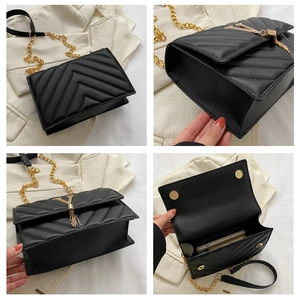 Détails du sac matelassé noir avec boucle en V dorée, pompon et bandoulière en chaîne